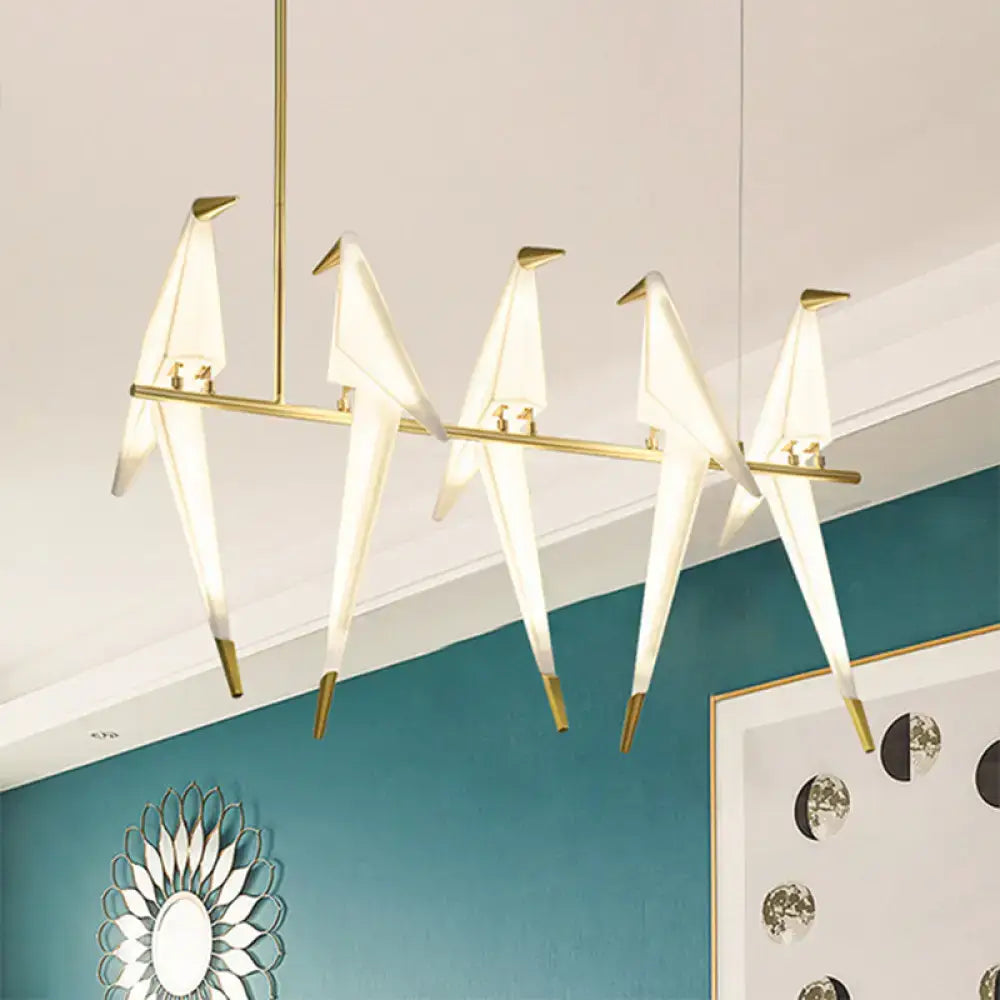 Modern gold-toned art deco acrylic bird island pendant light with five illuminated white and gold LED origami bird bulbs