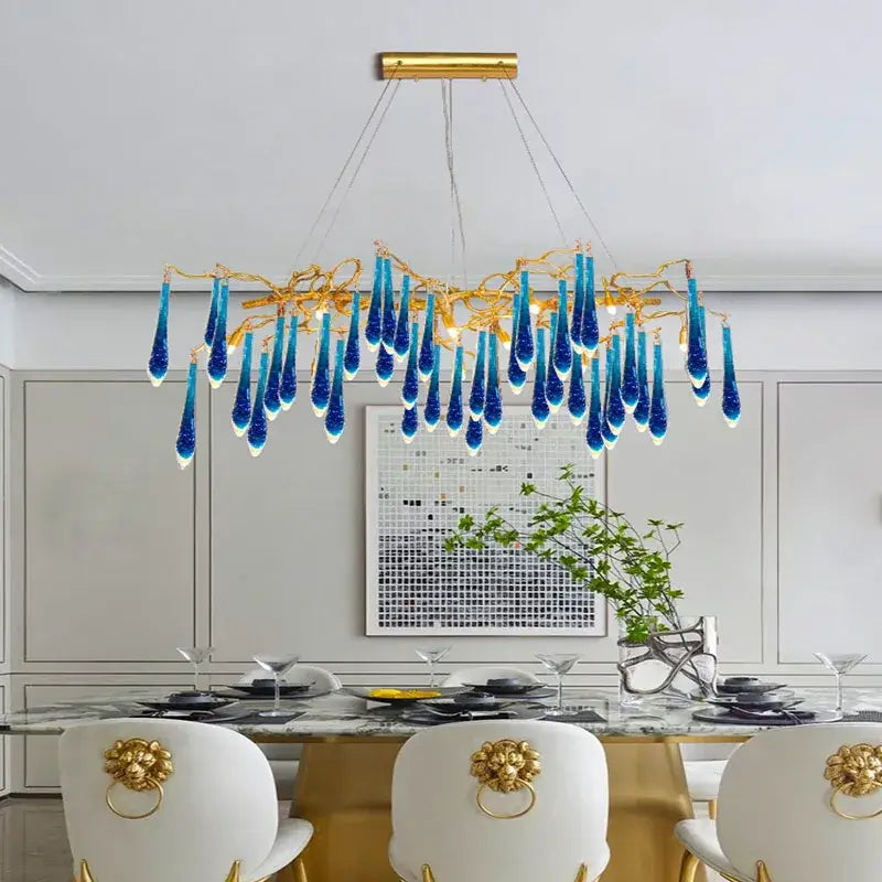 A decorbites art deco blue queen crystal chandelier with a golden frame and cascading blue glass teardrop pendants