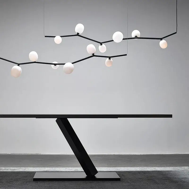 Black modern table with sleek angular base and minimalist design complementing decorbites art deco branches chandelier