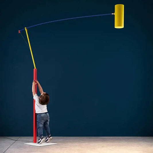 A vibrant yellow cylindrical floor lamp with red base and blue joint rotating arm by decorbites art deco colorful metal design