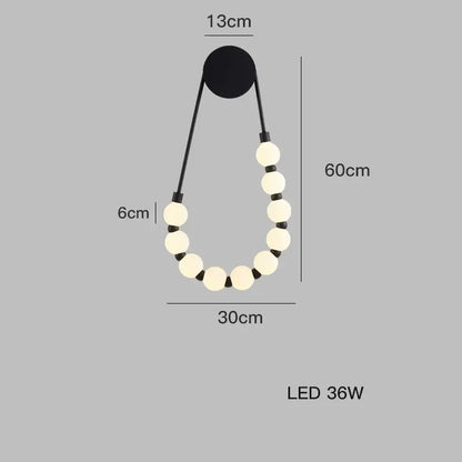 Black decorbites™ led wall sconce with cream glass bulbs and black cords forming an art deco teardrop shape