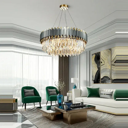 A decorbites art deco chandelier with a circular dark gray and gold frame and deco golden crystal strands
