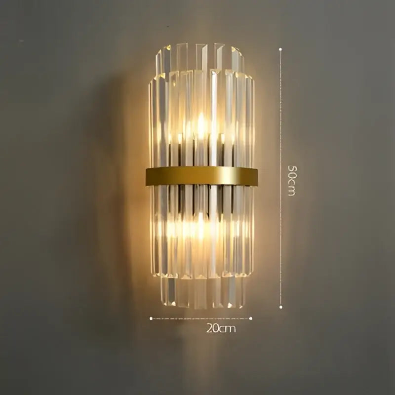 Decorbites art deco wall sconce with vertical crystal rods in gold-toned stainless steel emitting warm ambient light