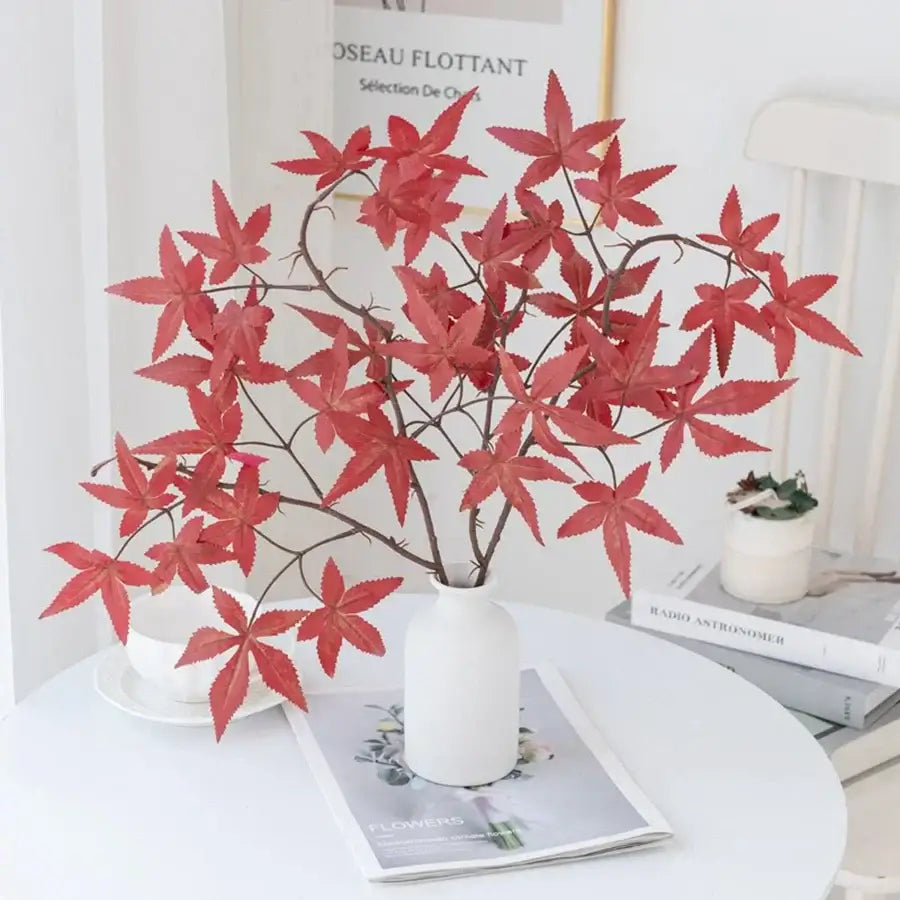 A vibrant red decorbites artificial maple leaf bouquet in a sleek white ceramic vase for wedding and home decor