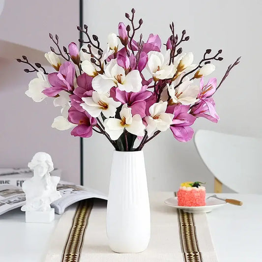 A decorbites artificial orchid magnolia bouquet with purple and white flowers in a tall white ceramic vase for decor
