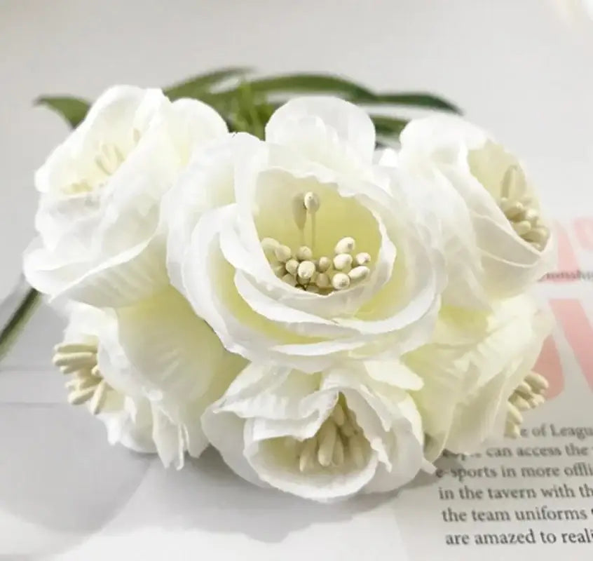 A delicate cluster of white decorbites artificial peony tea silk flowers with layered petals and subtle yellow centers