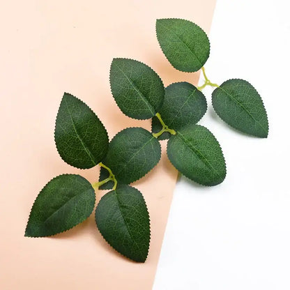 A cluster of green artificial rose leaves with detailed veins on thin stems for decorbites silk greenery wreaths