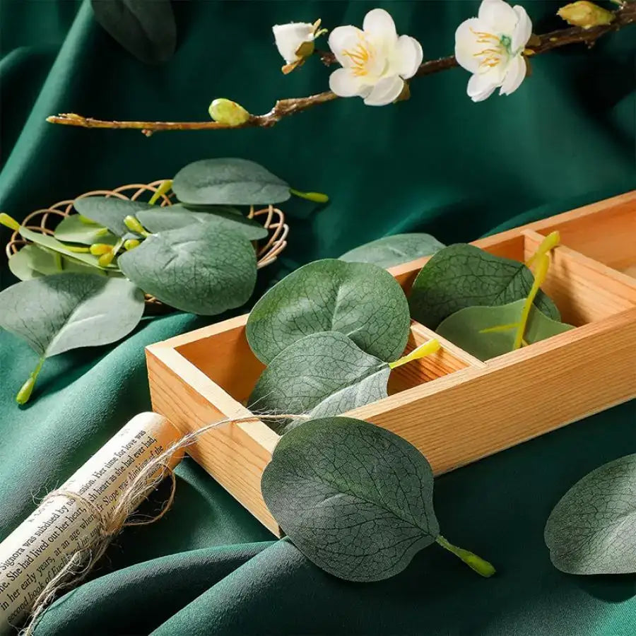 Light brown wooden tray with three compartments holding artificial eucalyptus leaves from decorbites artificial roses collection for home wedding christmas decor
