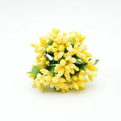 A cluster of yellow decorbites artificial stamen flowers made from textured synthetic material with green leaves
