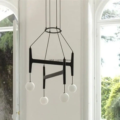 Black modern pendant light with geometric metal frame and four frosted glass globes decorbites astra wood pendant