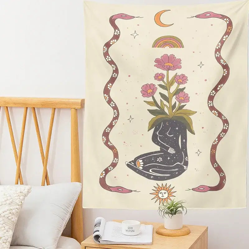 Cream-colored decorbites astrology tarot card tapestry with black seated figure, pink flowers, maroon snakes, and celestial accents
