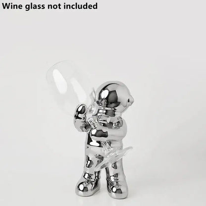 Shiny chrome decorbites astronaut ceramic figurine holding clear wine glass for a unique astronaut ceramic wine rack