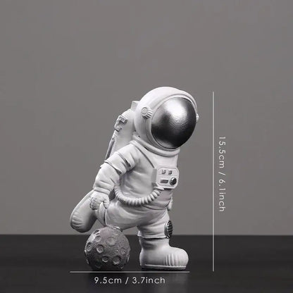 Decorbites astronaut figurine abstract sculpture features a white figure with metallic silver helmet on gray moon surface