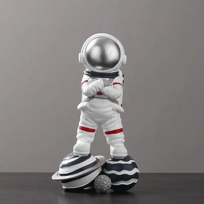 Decorbites astronaut figurine abstract sculpture featuring a white figurine with silver helmet and red accents on planets