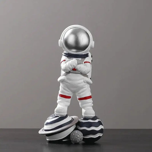 Decorbites astronaut figurine abstract sculpture featuring a white figurine with silver helmet and red accents on planets