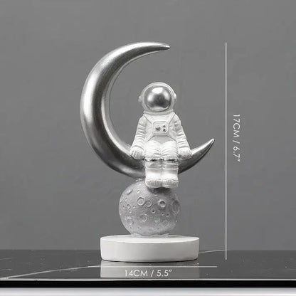 Silver decorbites astronaut figurines sitting on crescent moon with textured base modern spaceman sculpture gift idea