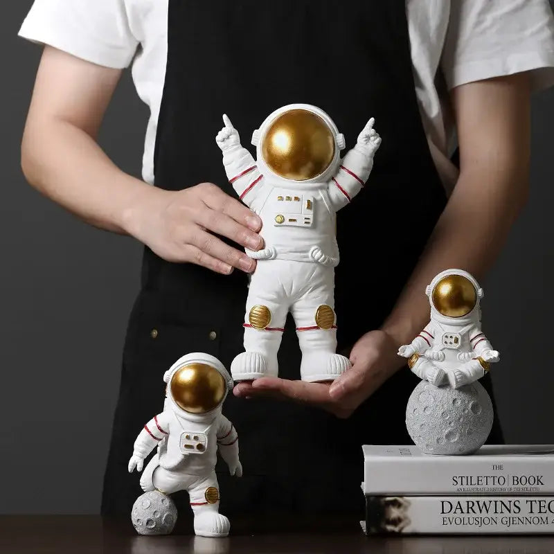 White astronaut figurine with gold helmet and accents in playful pose from decorbites astronaut figurines collection