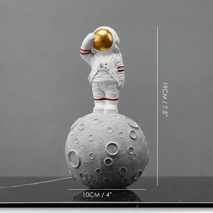 White astronaut figurine with gold helmet on textured gray moon base from decorbites astronaut figurines collection