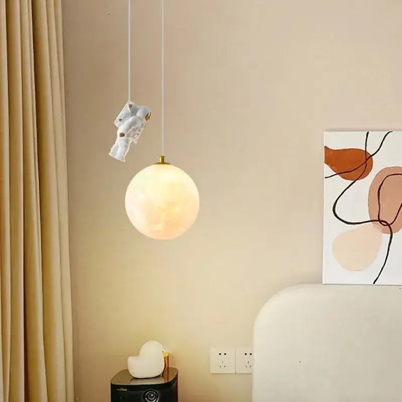 White ceramic pendant light with a glowing spherical moon shade from decorbites astronaut moon collection for childrens room