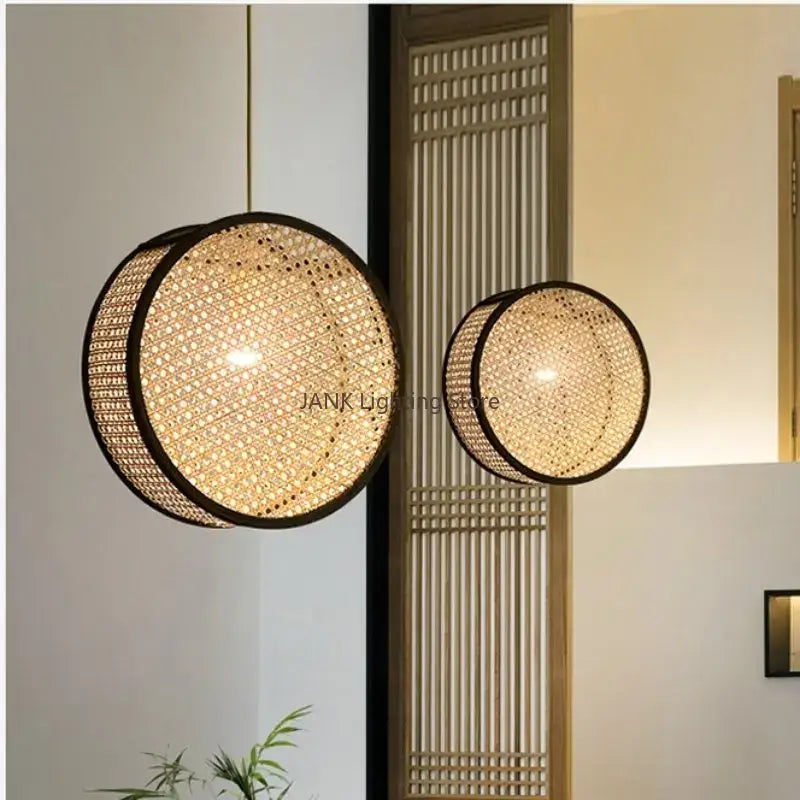 Two circular woven bamboo core rattan pendant lights with black frames by Decorbites emit warm kitchen light