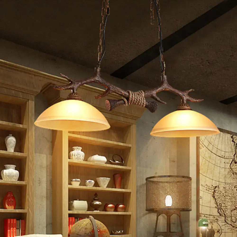 Rustic bronze antler ceiling light with two beige glass warm-toned shades and dark coffee accents suspended by chains and rope