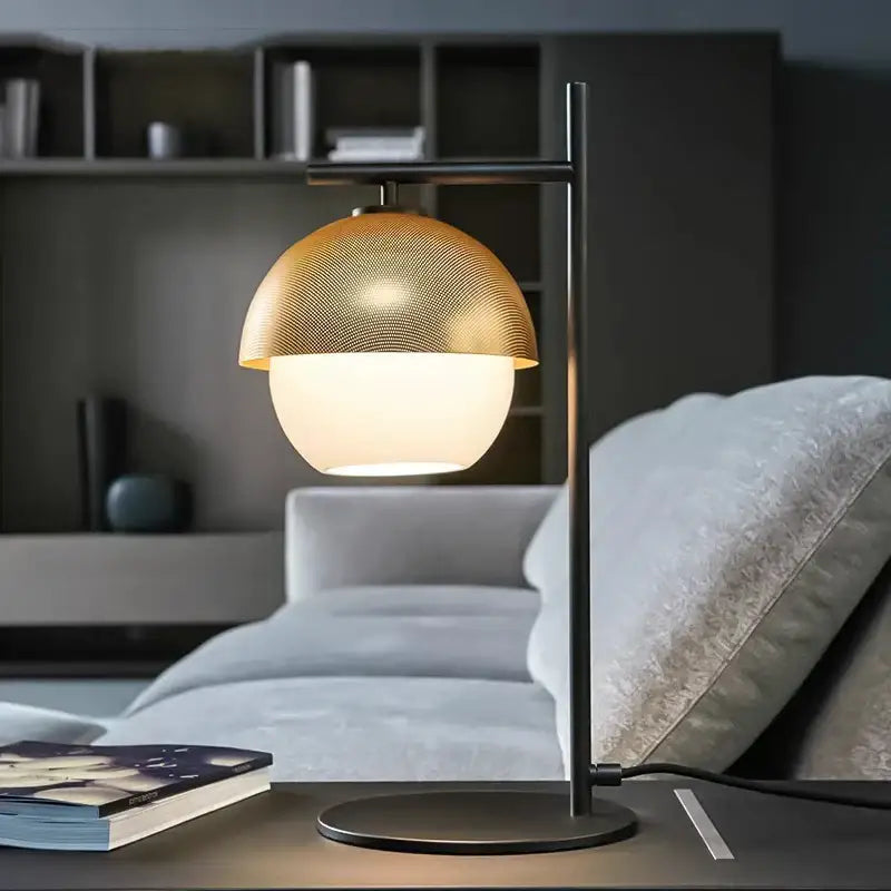 Gold-toned mesh globe floor lamp with frosted glass base on black metal stand by DecorBites black glass ball design