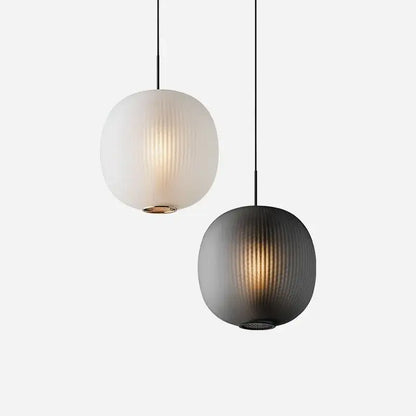 Two spherical pendant table lights with vertical ribbed glass ball shades in frosted white and matte black decorbites black glass