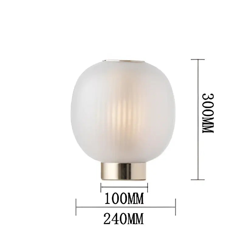 Decorbites black glass table light featuring a modern spherical frosted ribbed glass ball with brushed brass base