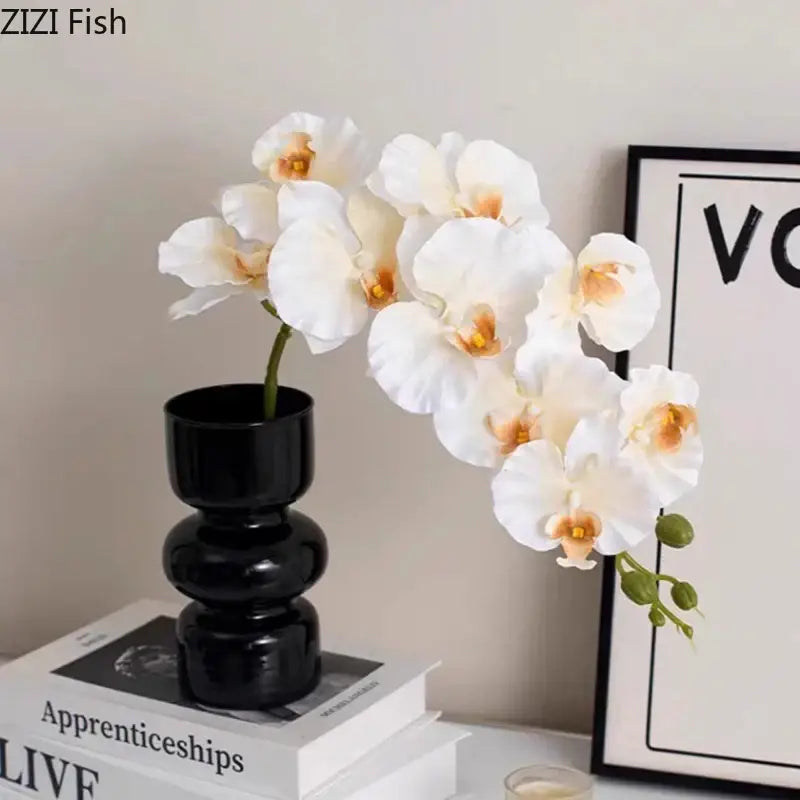 Elegant white artificial flowers arranged in a sleek decorbites black glass tiered vase for stylish room decor