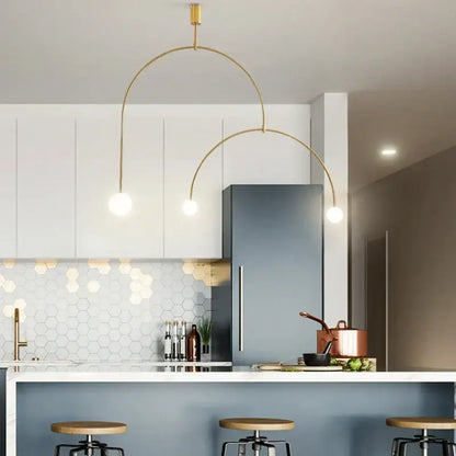 Decorbites black gold chandelier pendant with gold-toned arched design and spherical bulbs above modern kitchen island