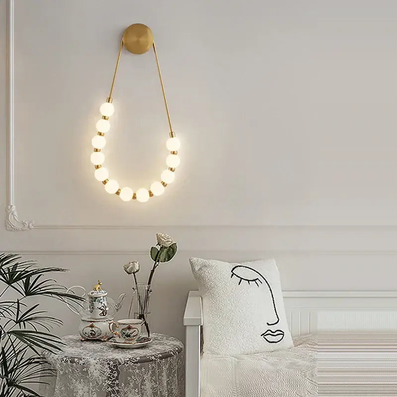 Gold-toned decorbites black gold led wall lamp with circular top and glowing spherical bulbs for bedroom and corridor