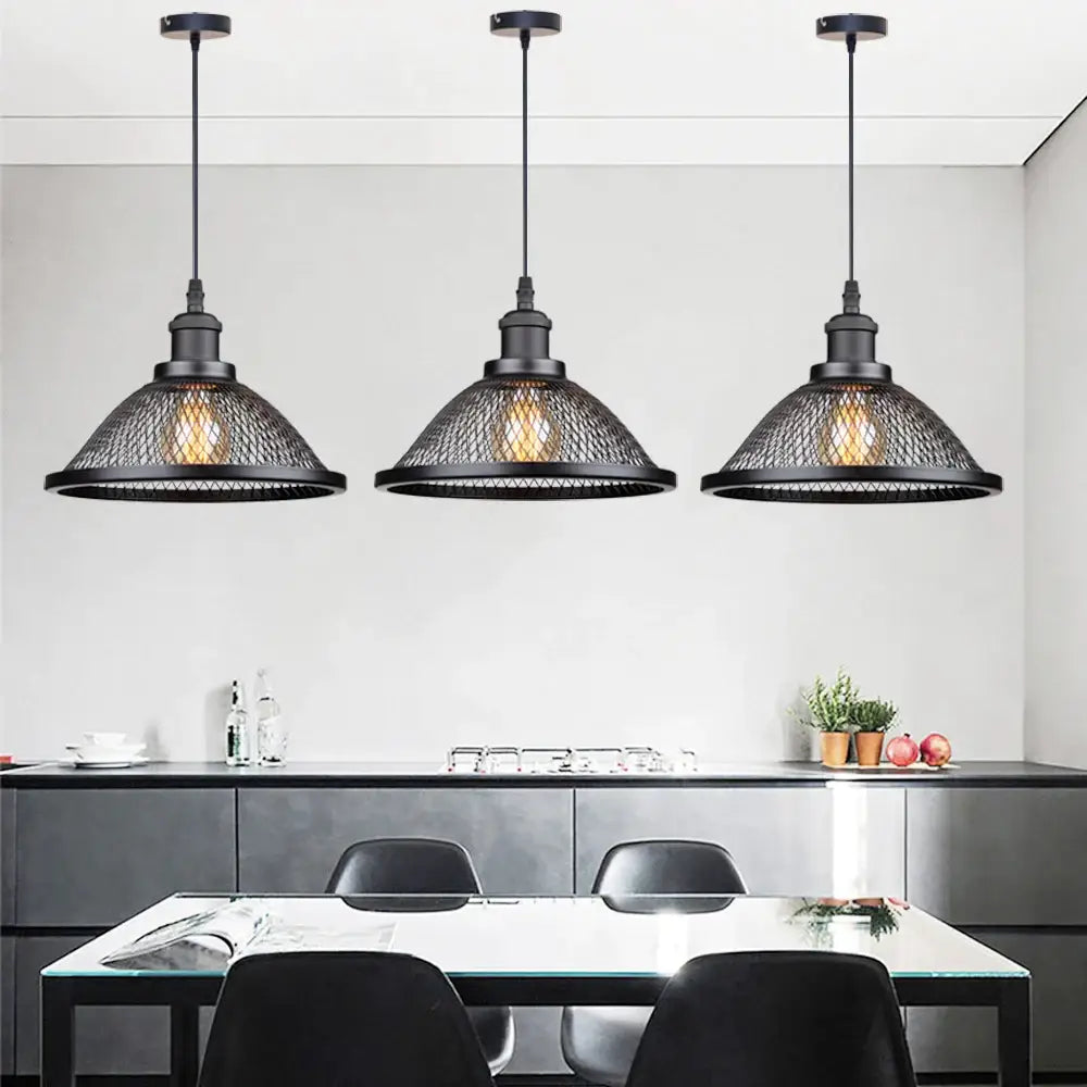 Three black industrial cage pendant lights by DecorBites hang above a dining table for kitchen island lighting