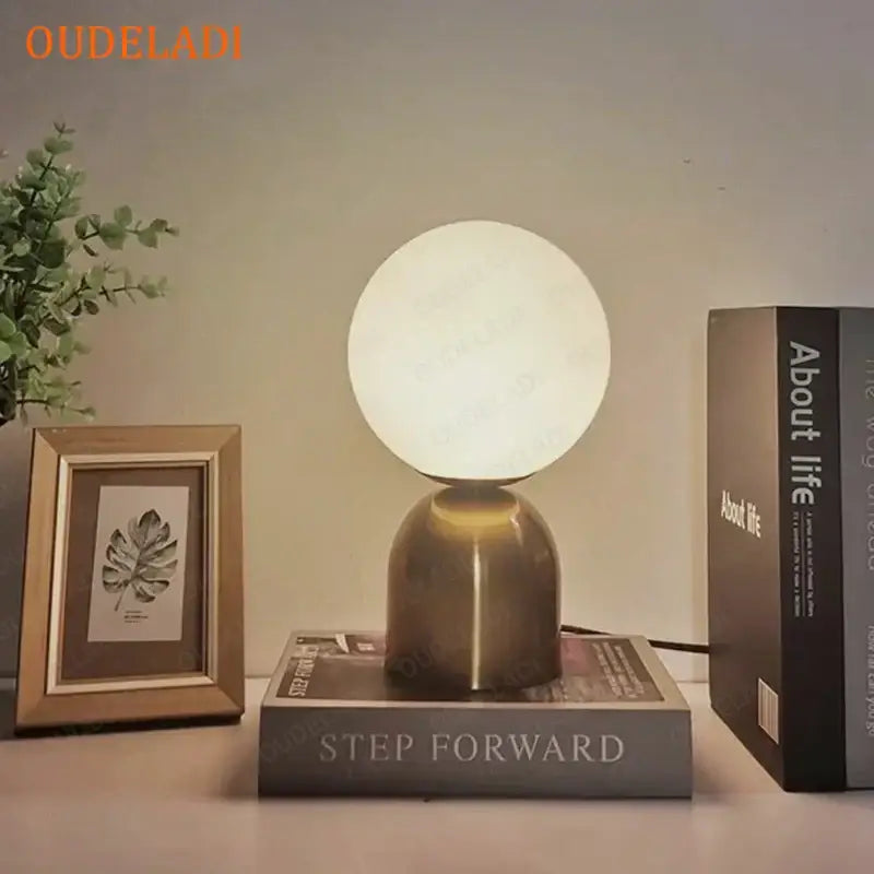 A decorbites black iron table lamp with a frosted white glass ball shade and brushed brass base for modern home decor