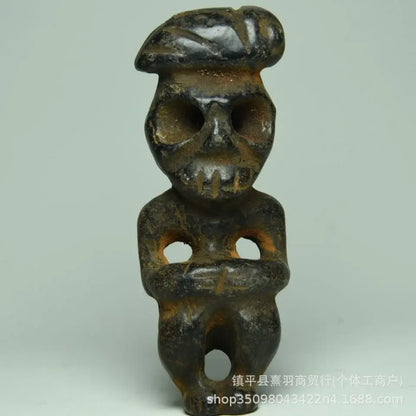 Dark weathered ceramic figurine with skull-like face and beret-style headwear from decorbites black iron meteorite sun statue
