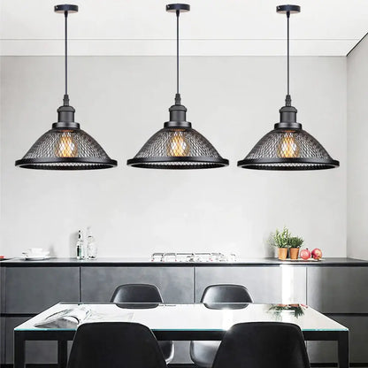 Three black iron mesh net-cage pendant light fixtures hang above a dining table for kitchen or living room use