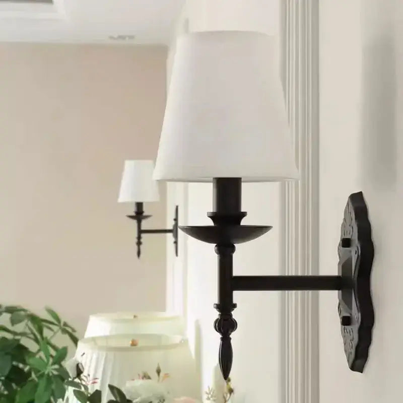 Decorbites black iron wall lamp with black wrought iron frame and white fabric shade for bedroom and living room decor