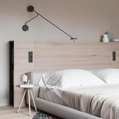 Modern decorbites black led wall reading light with sleek black metal arms and circular shades mounted above bed