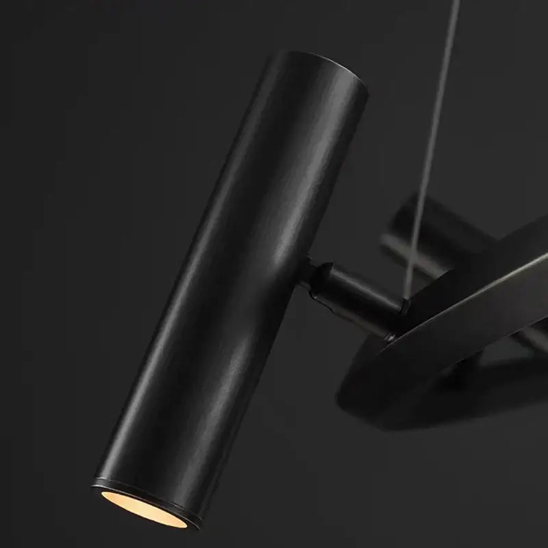 Decorbites black metal cylindrical pendant light with matte finish and warm glow in minimalist dining room chandelier design