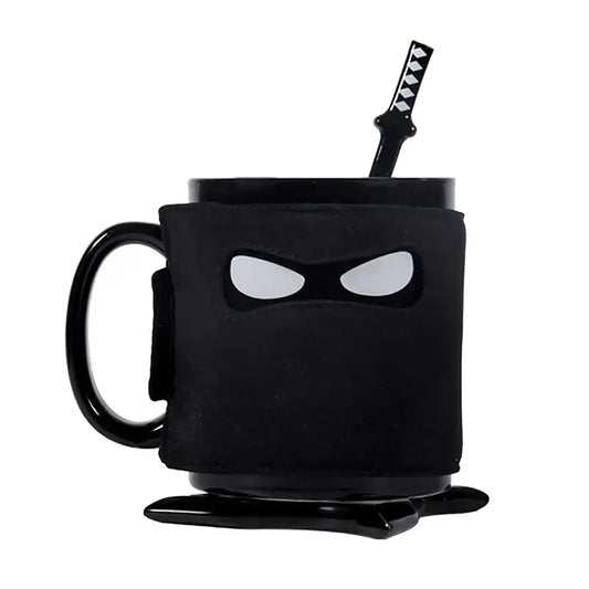 A decorbites black ninja mug with matte finish and white eye cutouts featuring a matching black sword stirrer