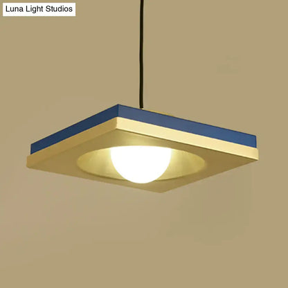 Modern blue and cream-colored pendant light with metal concave squares and warm glowing bulb base for bedrooms by DecorBites
