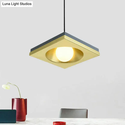 DecorBites™ blue and gold pendant light with square brass frame, dark gray bulb base, and illuminated circular bulb for bedrooms