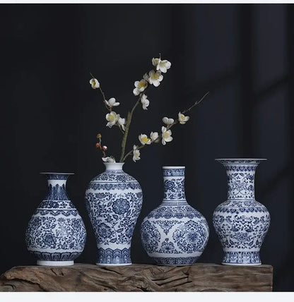 Four blue and white ceramic vases with intricate floral patterns displayed on a wooden surface for elegant home decor