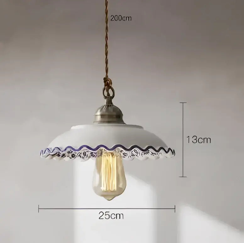 A vintage-style pendant light with a white ceramic shade and purple lace trim hanging above an edison bulb