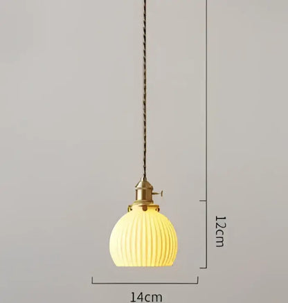 A warm yellow ribbed glass pendant light with brass fixture and chain contrasting decorbites blue glass pendant lights