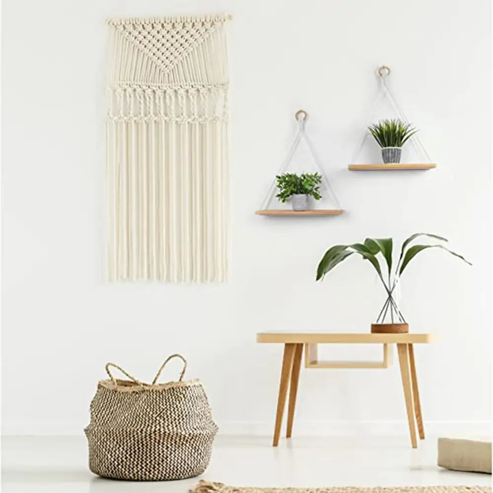 Cream-colored decorbites™ boho macrame hanging shelf with triangular top and long fringe for wall decor