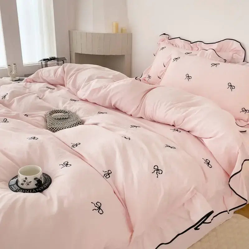 Pink decorbites™ bow embroidery bedding set with ruffles featuring black bow embroidery and ruffled edges