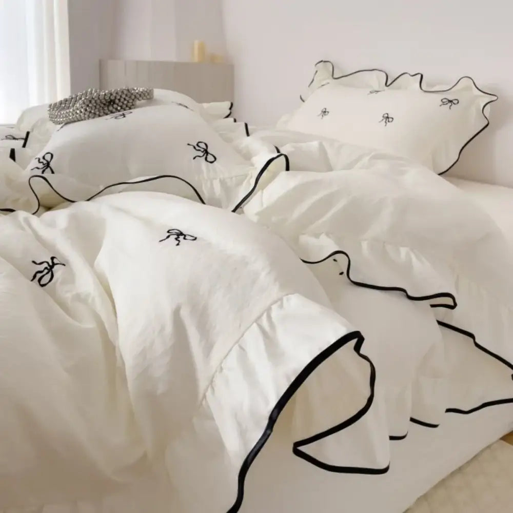 White bedding set with black bow embroidery and ruffled edges from decorbites™ bow embroidery bedding set