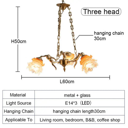 Antique brass-colored decorbites brass angel chandelier with ornate metal arms and amber flower glass for living room