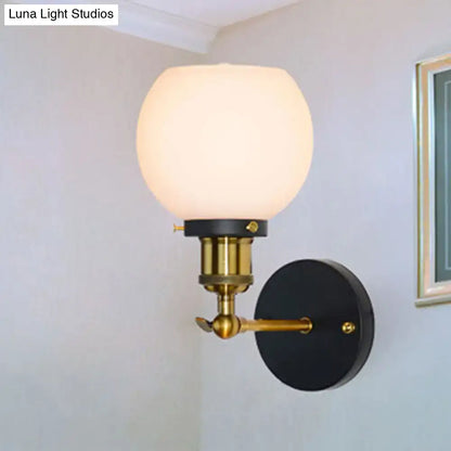 Industrial brass wall sconce with bubble white glass globe brass hardware and black backplate for bedroom lighting