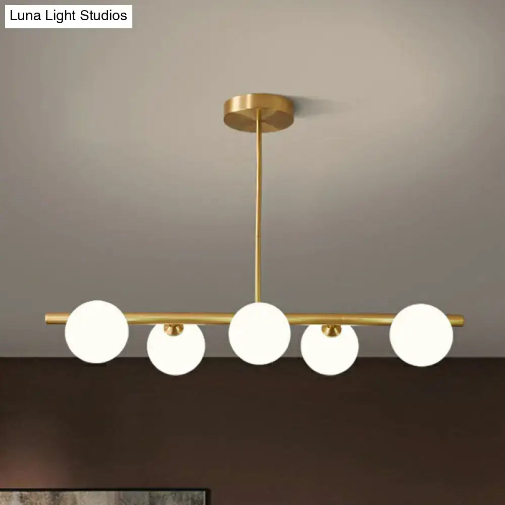 Decorbites brass plated glass sphere island pendant light with five frosted glass globe bulbs in clear white finish